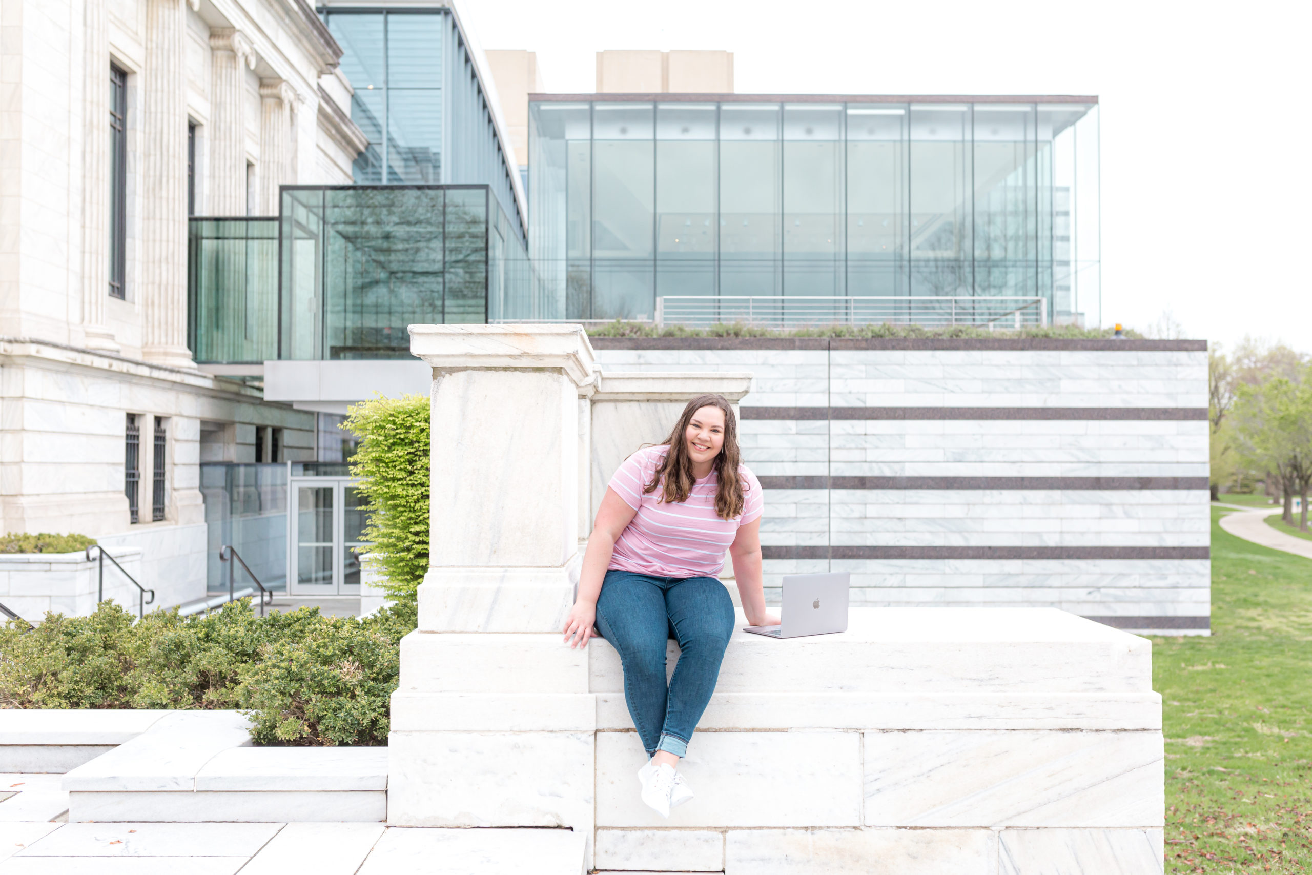 sitting with a computer on a ledge